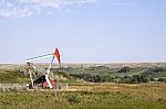 Oil Well In Grassy Field Stock Photo