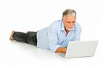 Old Man Lying With Laptop Computer Stock Photo