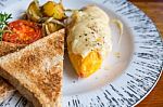 Omelet With Potato, Tomatoes Parsley And Feta Cheese And Bread In White Plate On Wooden Table Stock Photo