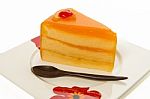 One Piece Of Orange Cake With Wooden Small Spoon Stock Photo