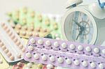 Oral Contraceptive Pills With Alarm Clock Background Stock Photo