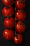 Organic Fresh Cherry Tomatoes On Black Board Background Stock Photo