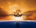 Passenger Jet Plane Flying Over Beautiful Sea Level With Sun Set Sky Above And Urban Skyline Behind Stock Photo