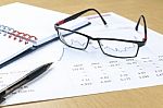 Pen, Notebook, Glasses And Financial Report Stock Photo