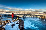 Photoghaper Taking A Photo At Godafoss Waterfall In Winter, Iceland Stock Photo