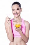 Picture Of Young Woman Eating Orange Stock Photo