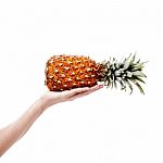 Pineapple In Female Hand On White Background Stock Photo
