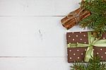 Polka Dot Gift With Christmas Decoration With Cinnamon And Pine Branches On White Wood Background Stock Photo