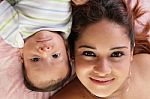 Portrait Of A Beautiful Hispanic Happy Mother With Baby Lying Do Stock Photo