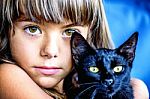 Portrait Of A Beautiful Little Girl Holding A Black Cat Stock Photo