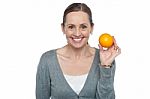 Portrait Of A Woman Holding Up An Orange Stock Photo