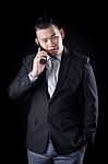 Portrait Of Asian Business Man Talking Mobile Phone Against Blac Stock Photo