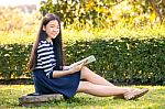 Portrait Of Asian Teen Twelve Years Old And School Book In Hand With Toothy Smiling Face Stock Photo