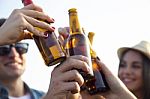 Portrait Of Group Of Friends Toasting With Bottles Of Beer Stock Photo