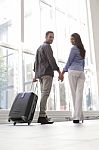Portrait Of Happy Couple With Luggage At Airport Stock Photo