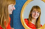 Portrait Of Redhead Girl Looking In Mirror Stock Photo