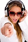 Portrait Of Smiling Woman Listening Music And Pointing At Camera Stock Photo