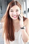 Portrait Of Thai Adult Beautiful Girl Using Her Smart Phone And Smile Stock Photo