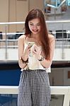 Portrait Of Thai Adult Beautiful Girl Using Her Smart Phone And Smile Stock Photo