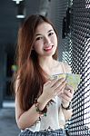 Portrait Of Thai Adult Beautiful Girl Using Her Smart Phone And Smile Stock Photo