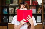 Portrait Of Thai Adult Student University Uniform Beautiful Girl Reading Red Book Stock Photo