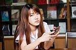 Portrait Of Thai Adult Student University Uniform Beautiful Girl Using Her Smart Phone Stock Photo