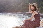 Portrait Of Young Beautiful Woman Wearing Long Dress And Wide Straw Hat Smiling At Sea Side Location Use For Modern Life Fashion And People Activities On Vacation Stock Photo