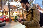 Portrait Of Young Man Using His Mobile Phone On The Street At Ni Stock Photo