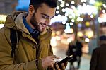 Portrait Of Young Man Using His Mobile Phone On The Street At Ni Stock Photo
