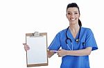 Portrait Of Young Nurse Pointing Blank Clipboard Stock Photo