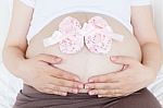 Pregnant Belly With A Pair Of Pink Shoes Stock Photo
