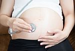 Pregnant Woman Using Stethoscope Stock Photo