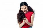 Pretty Chinese Girl Reading Funny Message Stock Photo