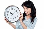 Pretty Girl Holding And Looking At Wall Clock Stock Photo