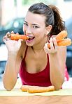 Pretty Woman Eating Carrots At Home Stock Photo