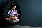 Pretty Woman On Bubble Chair Reading Magazine Stock Photo