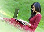 Pretty  Woman With Laptop On Green Grass At The Garden Stock Photo