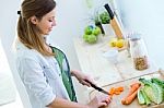 Pretty Young Woman Cutting Vegetables In The Kitchen Stock Photo