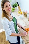 Pretty Young Woman Cutting Vegetables In The Kitchen Stock Photo