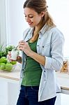 Pretty Young Woman Eating Yogurt In The Kitchen Stock Photo