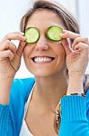 Pretty Young Woman Having Fun With A Cucumber In The Kitchen Stock Photo