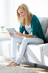 Pretty Young Woman Using Her Digital Tablet At Home Stock Photo