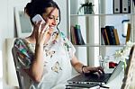 Pretty Young Woman Using Her Mobile Phone In The Office Stock Photo