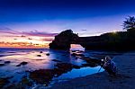 Professional Photographer With Camera And Tripod In Tanah Lot Temple At Sunset, Bali In Indonesia.(dark)seascape Stock Photo