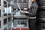 Programmer With Graph Icon In Data Center Room Stock Photo