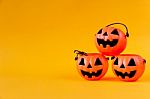 Pumpkins Bucket On Yellow Background Stock Photo