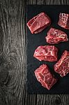 Raw Angus Beef Slices On The Black Stone  On The Wooden Table Vertical Stock Photo