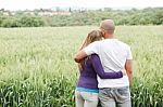 Rear View Of Couple With Arms Around Each Other Stock Photo