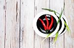 Red Hot Chilli Pepper And Green Onion On Plate Stock Photo