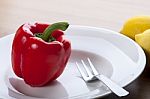 Red Paprika On White Plate With Fork Stock Photo